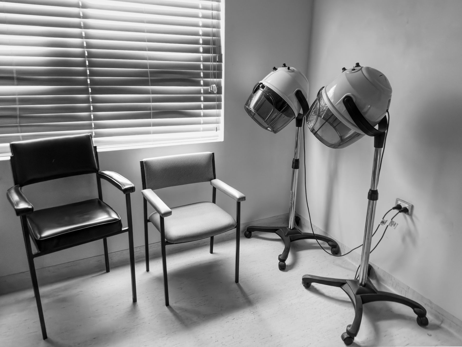 Salon chairs and hood dryers by a window